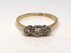 An antique 18ct gold three stone diamond ring, the central stone approx. 0.5 carat, size R.