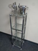 A metal and glass four tier stand containing bar accessories
