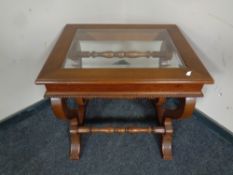 A reproduction Regency style glass topped coffee table