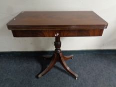A Victorian style mahogany turnover top card table on four way pedestal