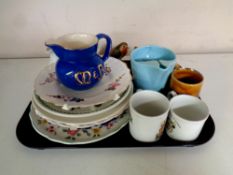 A tray containing assorted ceramics to include wall plates, commemorative mugs,
