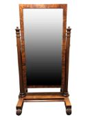 A Regency mahogany cheval mirror, of rectangular form, the base standing on inverted scroll feet,