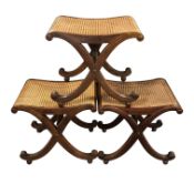 A set of three Regency style X-frame bergere stools in the manner of Gillows, height 46 cm,