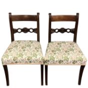 Five Regency inlaid mahogany dining chairs, with carved circular back motifs on sabre legs,