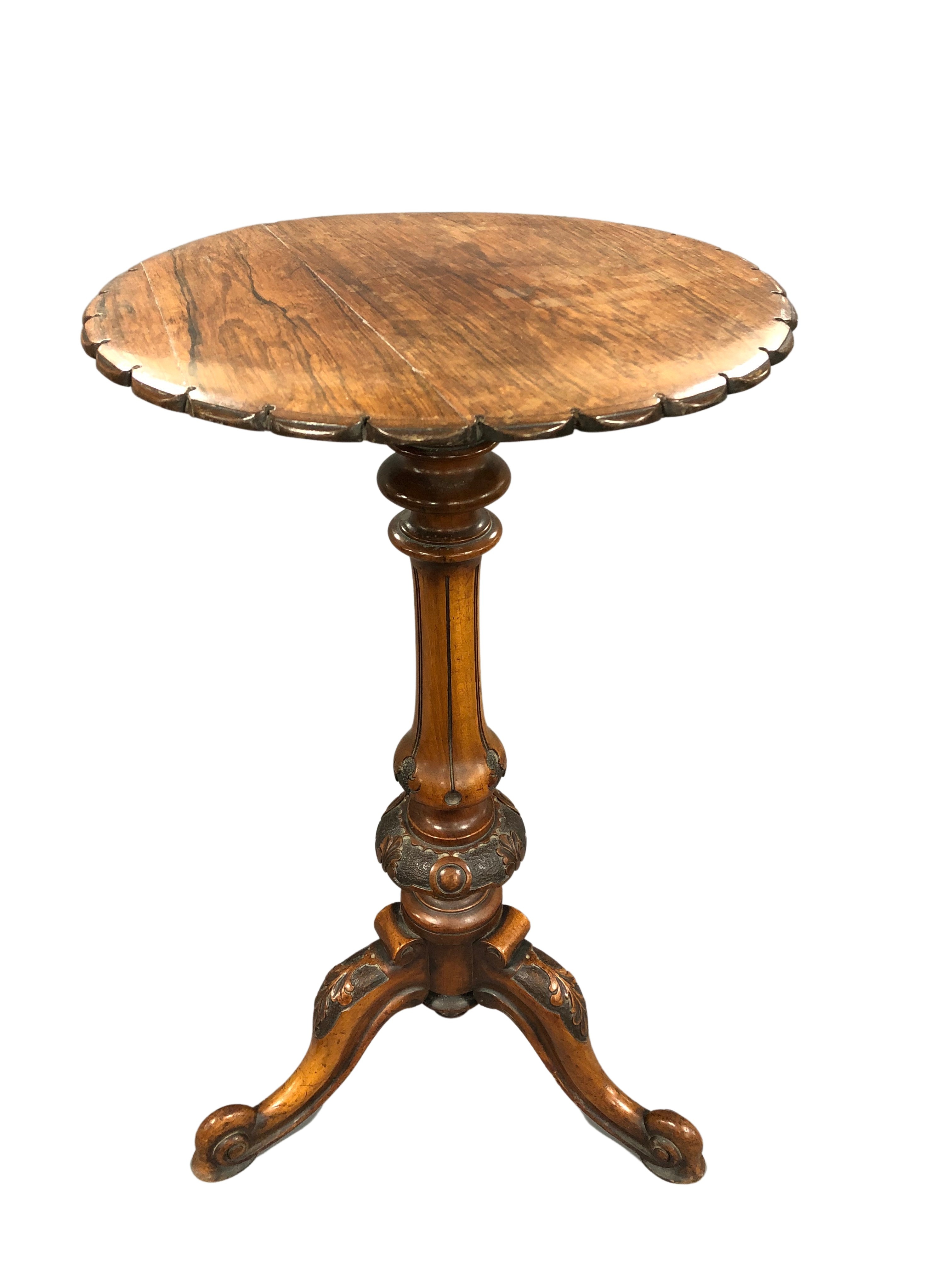 An early 19th century pedestal table on carved walnut tripod base and with rosewood shaped top,