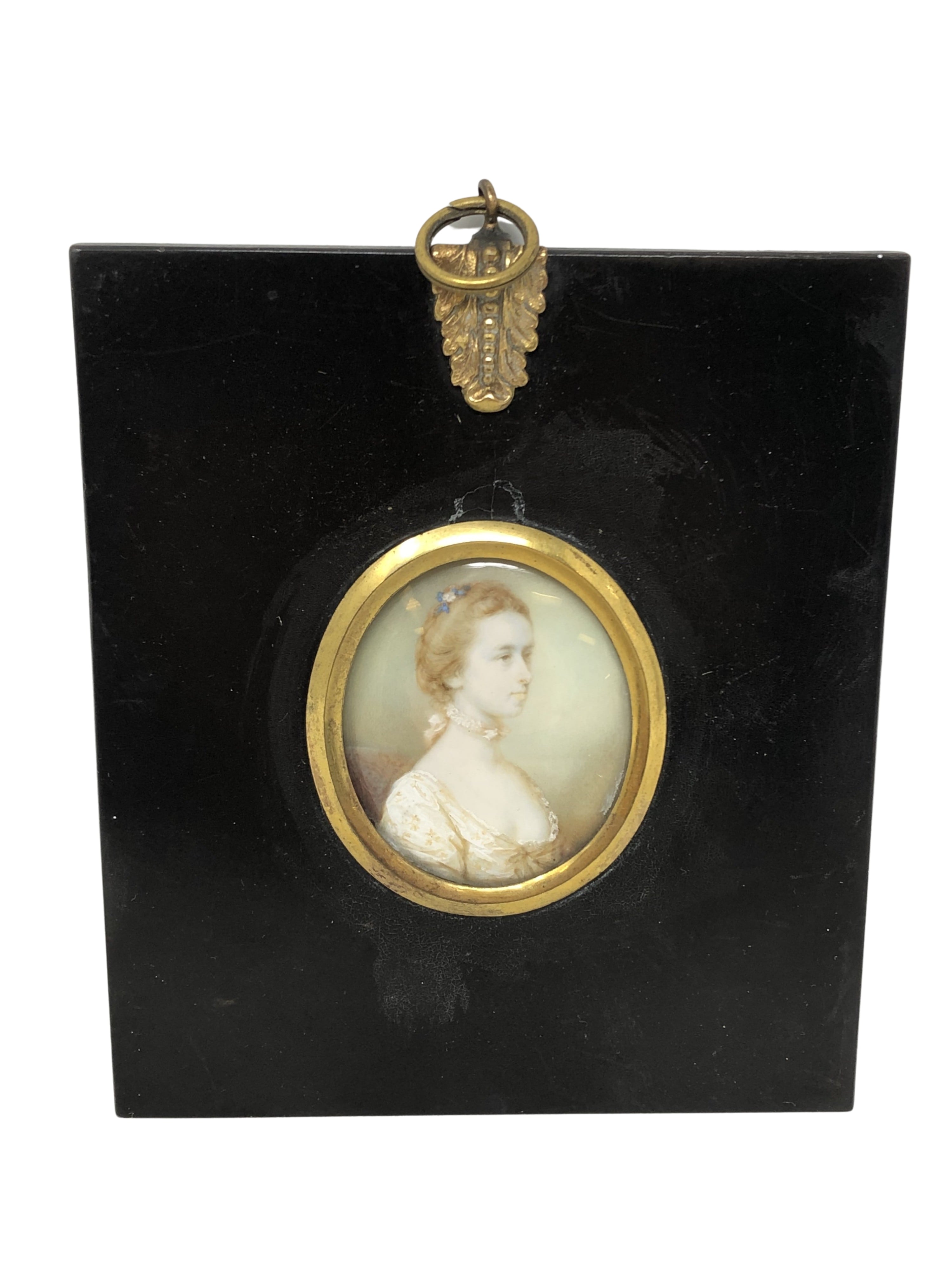 An early 19th century portrait miniature depicting a lady with blue ribbon in her hair, 4.5 cm x 3.