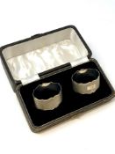 A boxed pair of oval silver napkin rings with engine turned decoration,