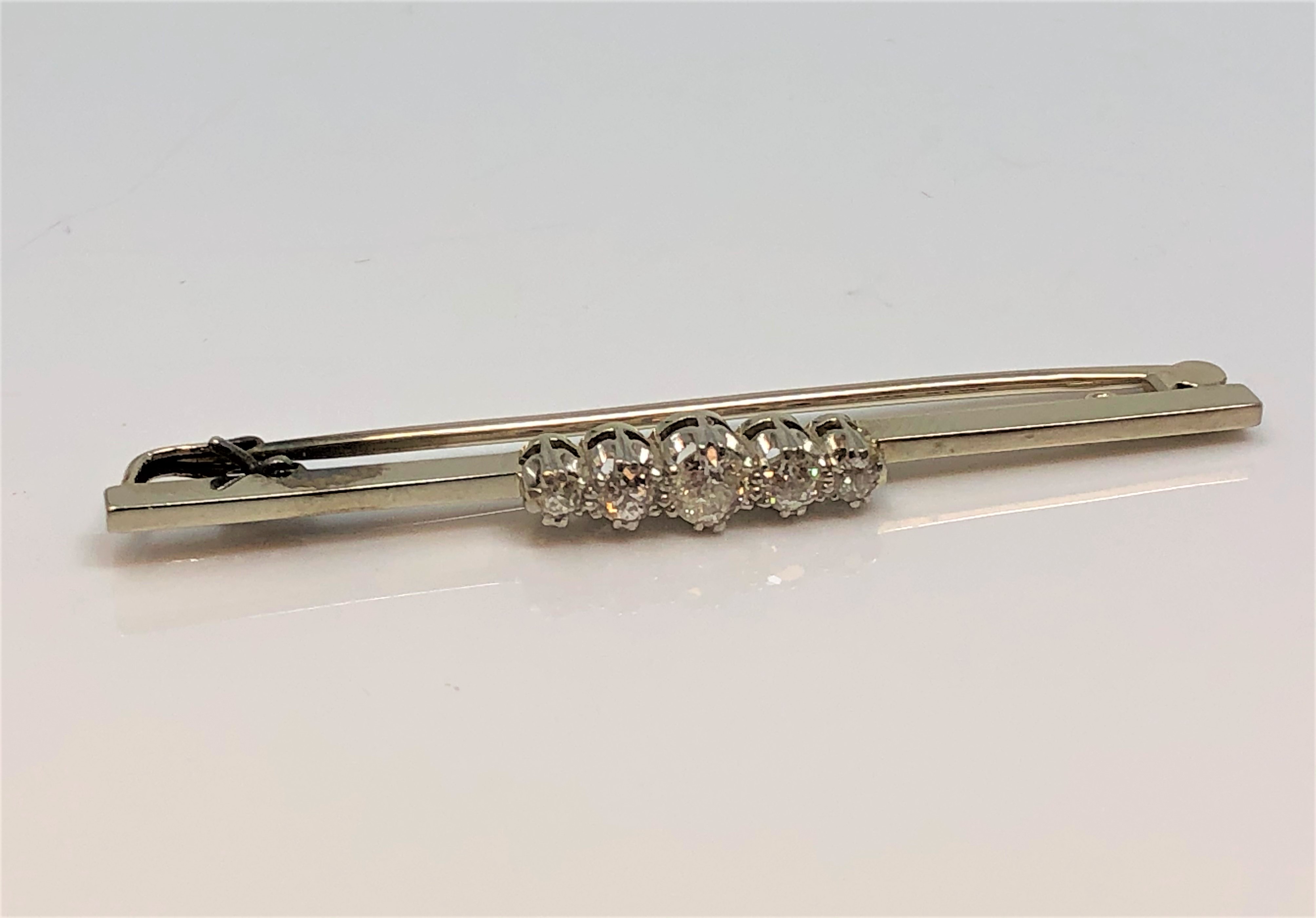 An 18ct gold and platinum five stone diamond brooch, approximately 0.9ct, 5.2g.