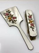 A two piece floral enamel and silver mirror and brush set