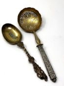 A 19th century silver strainer and a mid-Victorian silver gilt spoon dated 1856 (2)