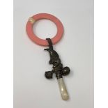 A silver rattle and teething ring modelled as Mr.