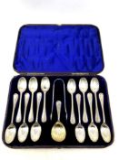 A Victorian cased set of twelve silver spoons, tongs and matching caddy spoon.