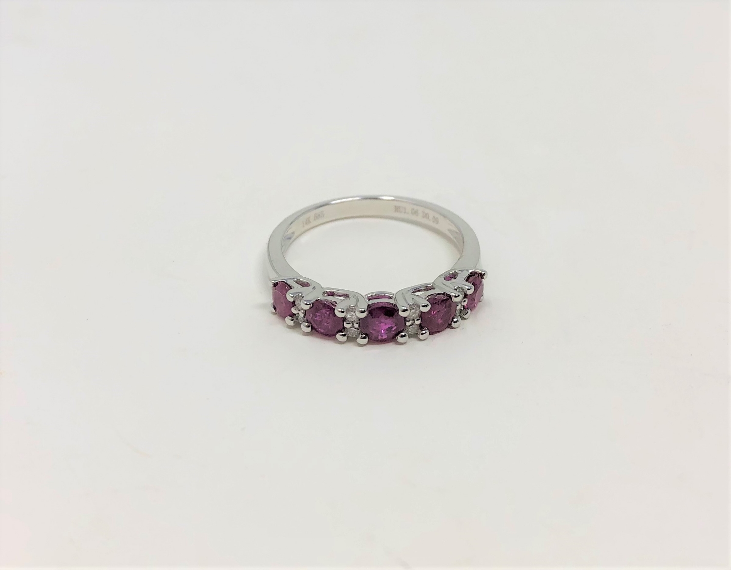 A 14ct white gold ruby and diamond ring, featuring five round cut rubies (1.