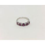 A 14ct white gold ruby and diamond ring, featuring five round cut rubies (1.