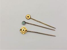 Three gold pins, two marked 15ct and set with diamond and ruby,