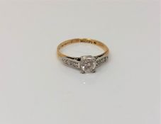 An antique 18ct gold diamond solitaire ring with diamond set shoulders,