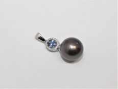 A 14ct white gold pearl, sapphire and diamond pendant, the oval-cut sapphire weighing 0.