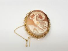 An ornate gold cameo brooch with gold safety chain