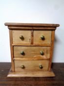 An antique pine apprentice piece four drawer chest