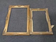 A double door storage cabinet in a mahogany finish together with two gilt frames