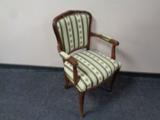 A carved beech salon armchair upholstered in a classical striped fabric
