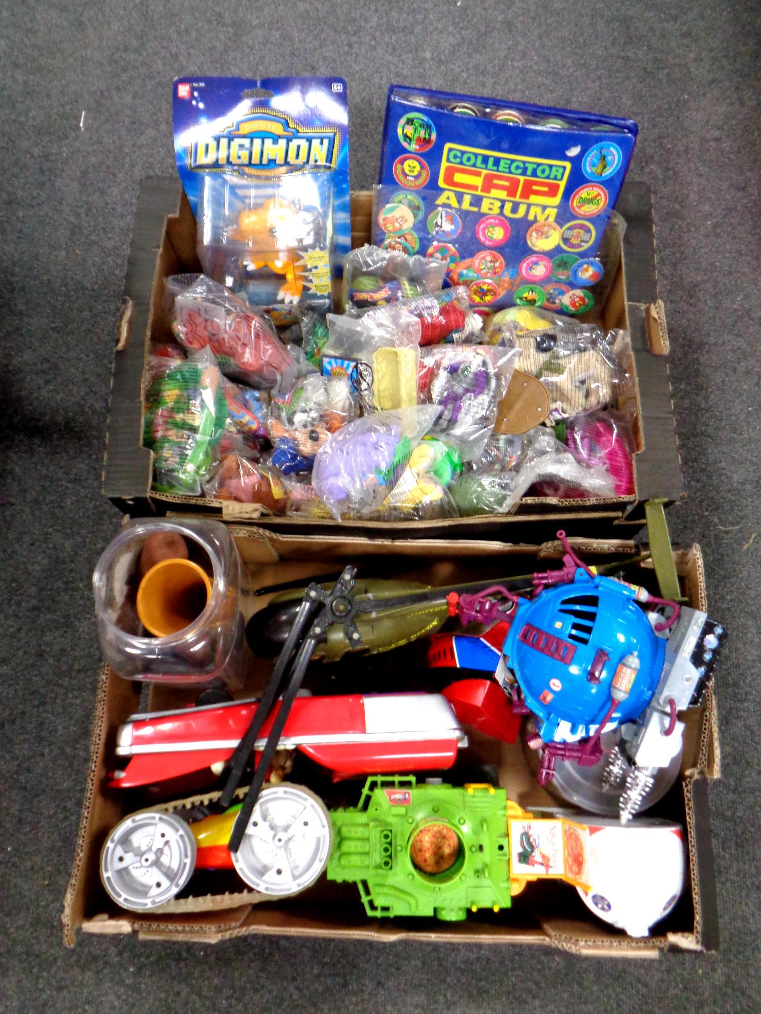 Two boxes containing miscellaneous toys to include micro machine play sets, TNMT vehicles,