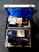 A tray containing two boxes containing a large quantity of costume jewellery to include brooches,