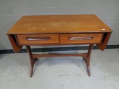 A mid 20th century teak G Plan flap sided sofa table fitted two drawers