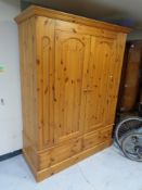A contemporary pine double door wardrobe fitted two drawers beneath,