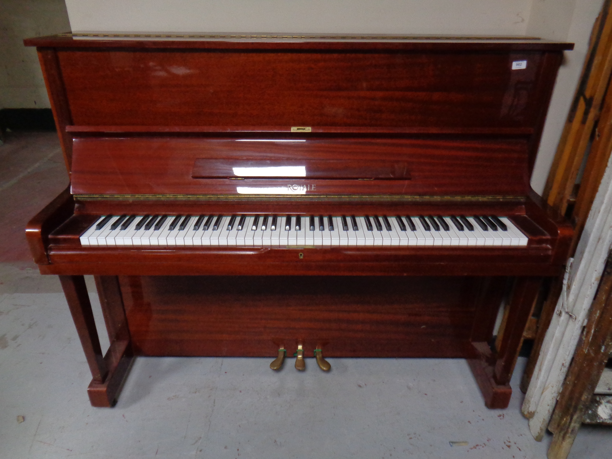 A Royale overstrung upright piano in a mahogany finish