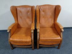 A pair of wood framed brown vinyl wingback armchairs