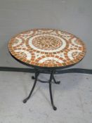 A cast iron mosaic topped patio table