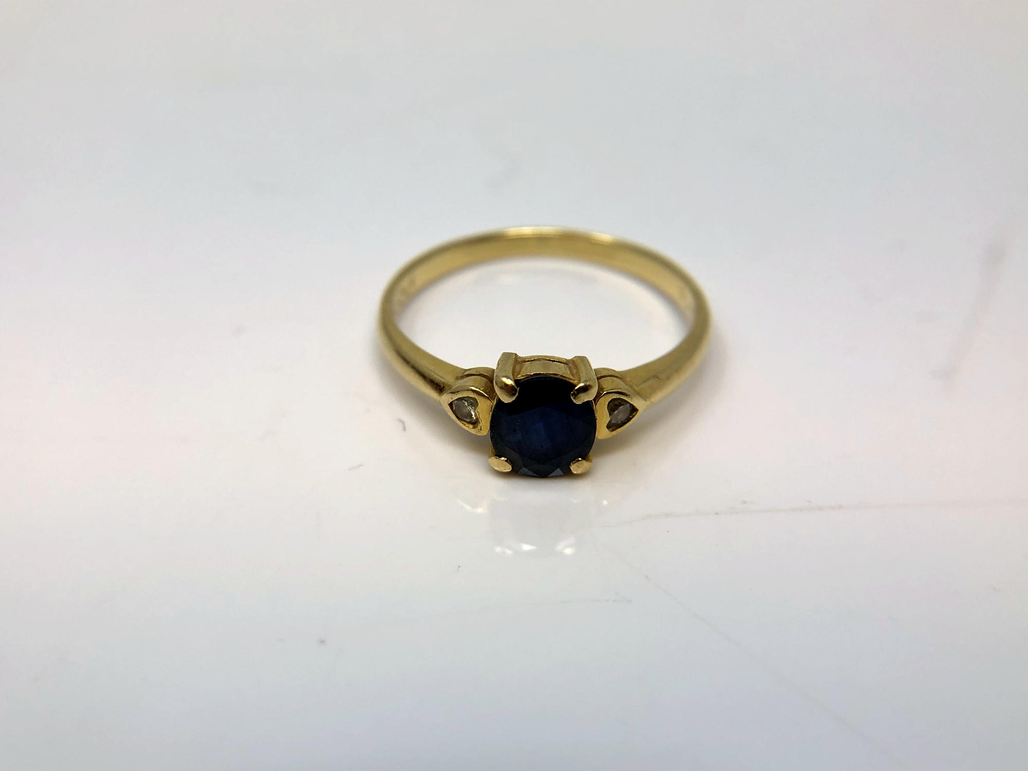 An 18ct yellow gold sapphire and two stone diamond ring, size M/N.