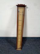 An antique stick barometer behind glass