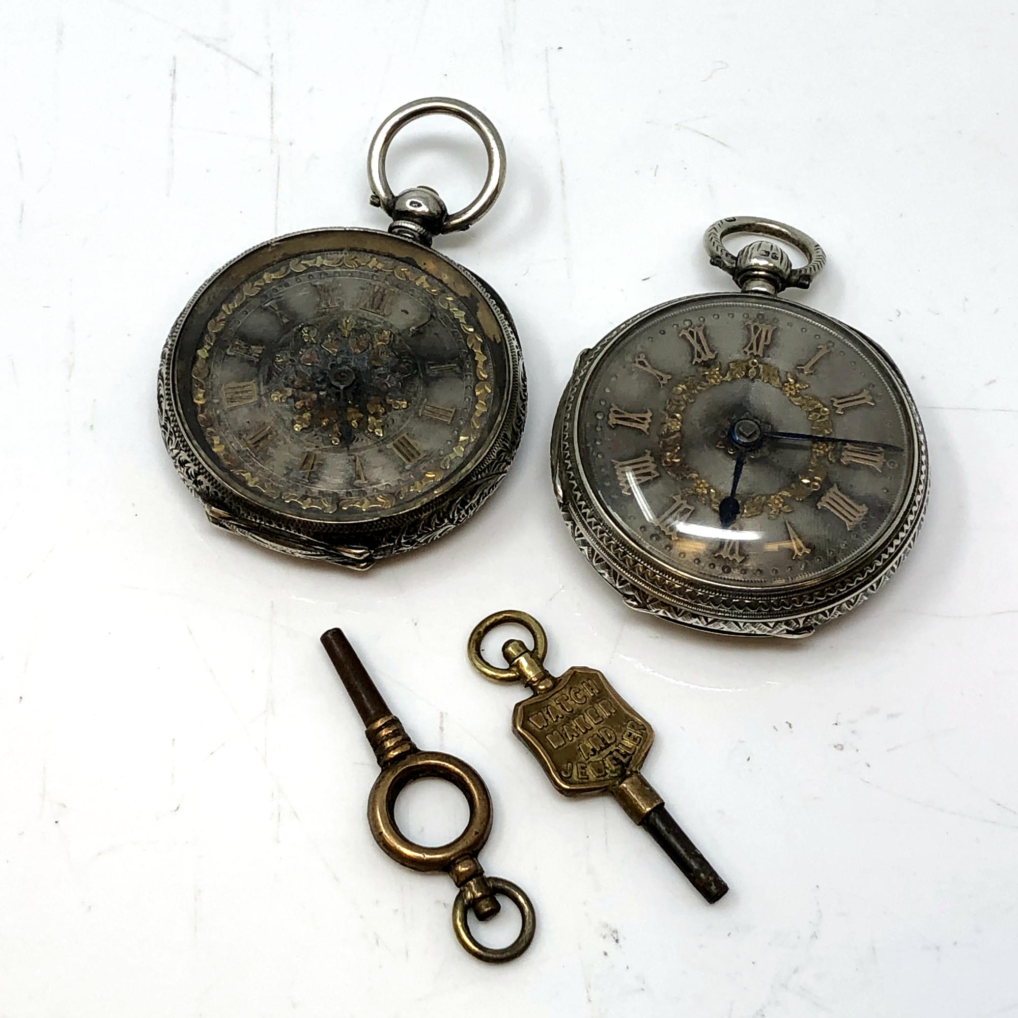 Two very ornate Victorian silver fob watches with gold detail on silver dials, one by JW Ramsay,