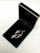 A silver dolphin brooch