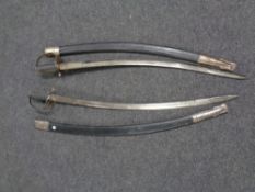 A pair of basket handled sabers in scabbards