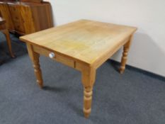 A pine farmhouse kitchen table fitted a drawer, 122 cm wide,