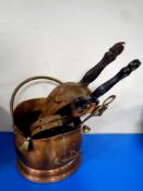 An antique copper coal bucket containing two sets of bellows, companion pieces,