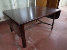 A Scandinavian flap sided coffee table in a mahogany finish