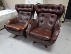 A pair of 1970s Parker Knoll brown button leather swivel armchairs on pedestals,