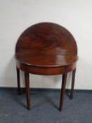 A George III mahogany turnover top D-shaped table