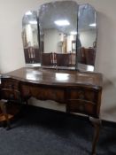 A 20th century serpentine dressing table with triple mirror