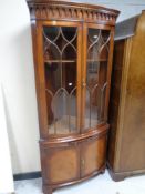 A Regency style mahogany corner display cabinet fitted cupboards and slide beneath