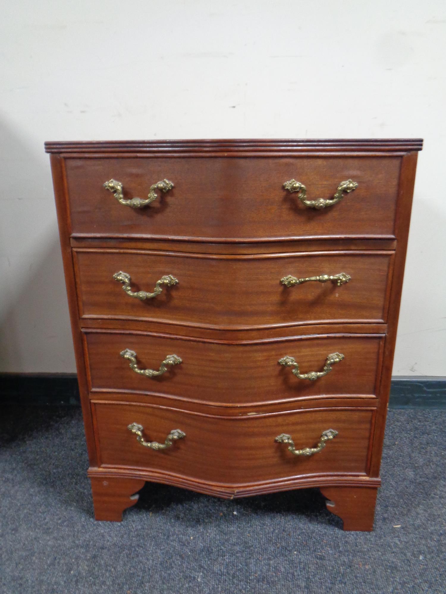 A Georgian style serpentine fronted four drawer chest