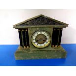 An antique onyx mantel clock with brass and enamelled dial