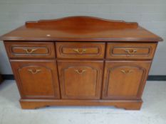 A Rossmore Furniture triple door sideboard fitted three drawers in a teak finish