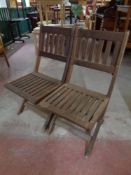 A pair of teak folding garden chairs