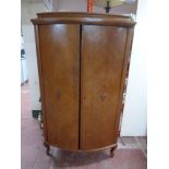 A 20th century continental oak bow fronted cabinet