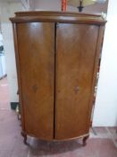 A 20th century continental oak bow fronted cabinet